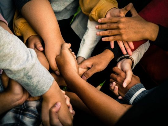 teamwork photo many different hands in a circle with various skin tones